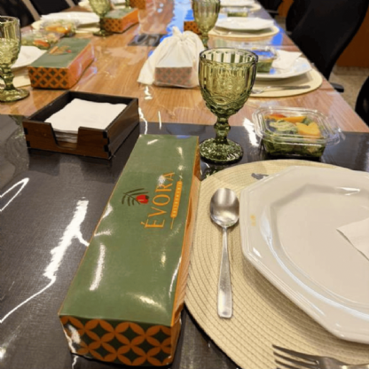 Embalagem para marmita executiva retangular exibida em mesa posta para evento ou refeição corporativa.