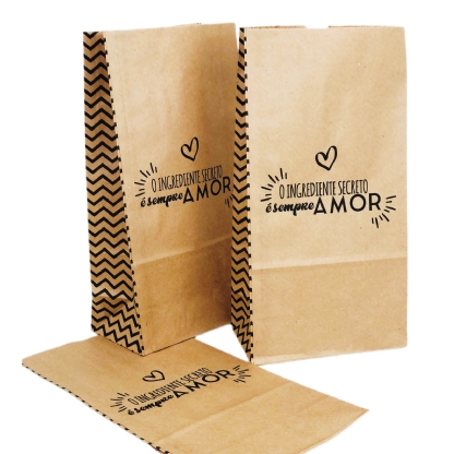 Sacos Kraft medindo 18 x 10,5 x 36 cm com a mensagem "O ingrediente secreto é sempre Amor", disponíveis em pacotes de 100 unidades, perfeitos para embrulhos temáticos e decorativos.